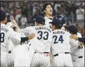  ?? Associated Press ?? Japan pitcher Shohei Ohtani (top) celebrates after defeating the United States 3-2 in the World Baseball Classic championsh­ip game, Tuesday, in Miami.