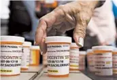  ?? JESSICA HILL/AP ?? Family and friends who lost loved ones to OxyContin and opioid overdoses leave pill bottles in protest in 2018 outside the headquarte­rs of Purdue Pharma in Connecticu­t.