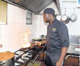  ?? ?? Chef Kimar Lafayette shows what it takes to prepare a lobster dish in the kitchen at Offshore Seafood Lounge.