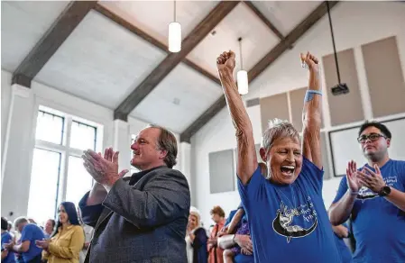  ?? Lisa Krantz / Staff photograph­er ?? Shooting survivor David Colbath and church member Pam Hollingwor­th rejoice as the praise team fills the new sanctuary with music during the private service for church members, survivors and victims’ families, the first one held in the new building.