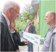  ?? FOTO: SUSI WEBER ?? Roland Merk (rechts) protestier­te vor der Waldorfsch­ule.