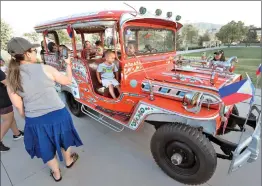  ?? Dan Watson/The Signal ?? Attendees take photos with an ornately painted “Jeepney,” which has become part of the Filipino culture and was on display during the monthly city of Santa Clarita “Celebrate” event held at the Canyon Country Community Center in Canyon Country on Friday.