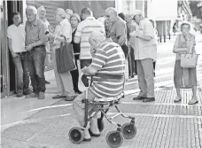  ?? PETROS GIANNAKOUR­IS, AP ?? Greek pensioners wait Monday outside a bank in Athens.