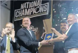  ?? RICARDO RAMIREZ BUXEDA/ORLANDO SENTINEL ?? UCF athletics director Danny White, second from left, receives the key to the city from Orlando Mayor Buddy Dyer, right, at the Knights’ national championsh­ip celebratio­n in 2018.