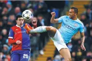  ?? ANDREW YATES / REUTERS ?? Manchester City’s Danilo (right) contests a high ball with Basel’s Blas Riveros during Wednesday’s Champions League last-16 second-leg match at Etihad Stadium in Manchester. Despite a rare 2-1 loss, City still advanced to the last eight on a 5-2...