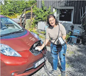  ?? FOTO: DPA ?? Loiuse Brunborg-Naess aus Son bei Oslo (Norwegen) lädt ihren Elektro-Nissan auf. Dank zahlreiche­r Vergünstig­ungen und Steuerbefr­eiungen können E-Autofahrer in Norwegen 3500 Euro im Jahr sparen.