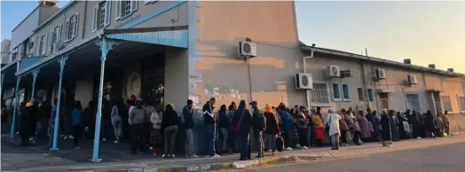  ?? Photo: Jackie Grove ?? The queue outside Dr Davies Optomotris­ts in Bathurst Street snakes into Queen Street on Mandela Day morning.