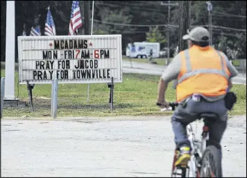  ?? JAY REEVES / ASSOCIATED PRESS ?? A bicyclist rides past a sign urging prayer for 6-year-old Jacob Hall, who was injured critically during a school shooting in Townville, S.C., on Thursday. Authoritie­s say a teacher and one other student also were wounded.