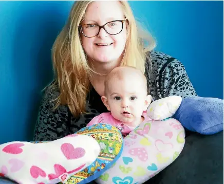  ?? PHOTO: MARK TAYLOR/STUFF ?? Andrea Olliver-Thompson, with her daughter 11-month-old Clara, makes material hearts filled with rice to the weight of ‘angel babies’.