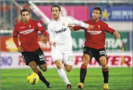  ??  ?? Real Madrid’s Gonzalo Higuain (centre) duels with Mallorca’s Joao Victor and Victor Casadesus. Higuain scored the equaliser in Real’s 2-1 win on Saturday.