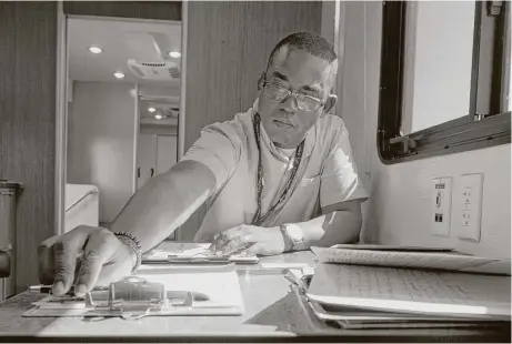  ?? Jason Fochtman / Houston Chronicle ?? Veterans Outreach Program Specialist Marcus Smith goes through paperwork on Sept. 7 after visiting with a veteran at the Veterans Affairs’ Mobile Vet Center in Porter. The mobile center is one of six such service centers in Houston.