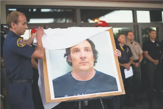  ?? Noah Berger / Special to The Chronicle 2016 ?? Fire officials unveil a picture of Damin Pashilk while announcing his arrest for 17 counts of arson during a community meeting in Middletown in August 2016.