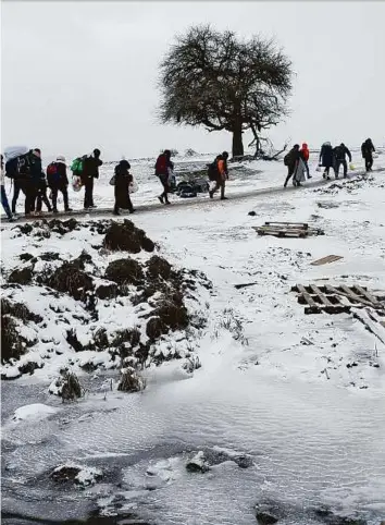  ?? Reuters ?? Refugees walk through a frozen field after crossing the border from Macedonia, near the village of Miratovac, Serbia yesterday.