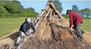  ?? Pictures: Andrew Matthews ?? > Veteran Jesse Swanson, left, joins Butser Ancient Farm’s Will Scanlan as they thatch the roof. Below, veteran Kevin Reilly from Southsea applies daub to some wattle