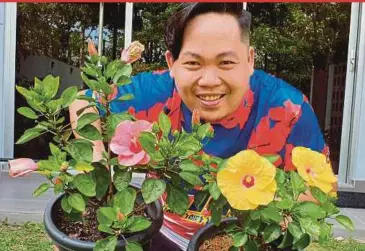  ?? BERNAMA PIC ?? Chamberlai­n Michael Abu showing his potted hibiscus plants at his home in Kuala Lumpur yesterday.