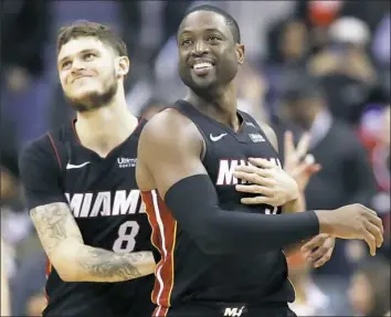  ?? Alex Brandon/Associated Press ?? On Wednesday, Miami Heat guard Dwyane Wade, right, visited Marjory Stoneman Douglas High School in Parkland, Fla., where 17 people — mostly students — were shot and killed last month.