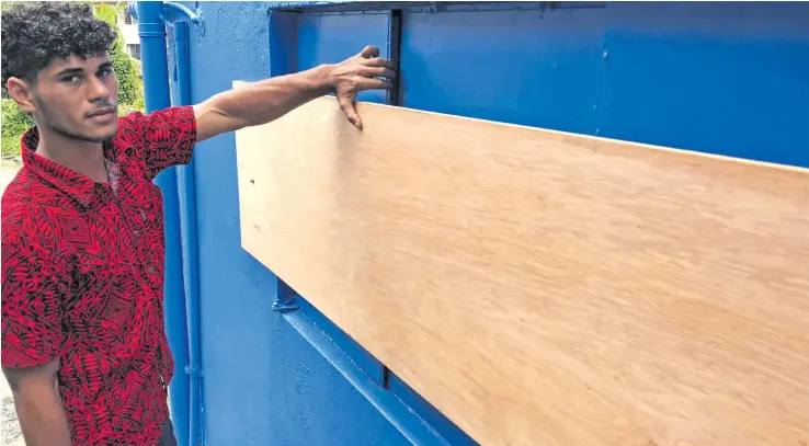  ?? Photo: Selita Bolanavnua ?? FijiFirst volunteer Eughenio Valentine shows where the attempts to break into the building was done. It has been covered with a thick ply board.