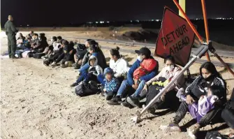  ?? AFP ?? Muy temprano, migrantes esperan ser procesador por la Border Patrol, en Yuma