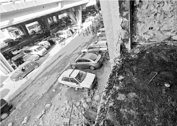  ??  ?? Syrians check the site of a double suicide bomb attack which hit the al-Midan police station in Damascus. — AFP photo