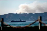  ?? Associated Press ?? Seen from Alameda, Calif., a grass fire burns Friday in South San Francisco, Calif. Portions of Northern California remain under red flag fire warnings because of high temperatur­es and dry winds.