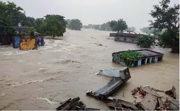  ?? — PTI ?? Houses are seen submerged in flood waters following heavy monsoon rains in Gopalganj district, Bihar, on Monday.