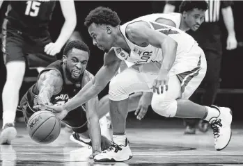  ?? Tim Nwachukwu / Getty Images ?? Hartford's Austin Williams, left, dives for a loose ball against Baylor's L.J. Cryer during Friday's first-round game at Lucas Oil Stadium. Wisconsin or North Carolina await Baylor in the second round.