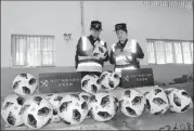  ?? GUAN YUE / FOR CHINA DAILY ?? Customs officials in Guangzhou examine soccer balls suspected of infringing the copyright of the FIFA World Cup.