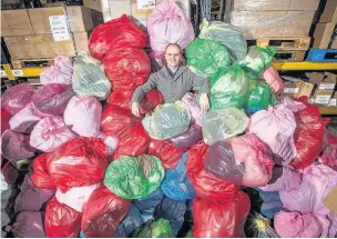  ??  ?? ●●Jonathan Bunting, chief operating officer of Smiths News, with donations during last year’s Pass It On campaign