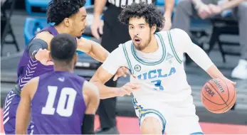  ?? MARK HUMPHREY/AP ?? UCLA’s Johnny Juzang (3) is defended by Abilene Christian’s Coryon Mason, left, and Reggie Miller (10) the second round of the NCAA Tournament on Monday.