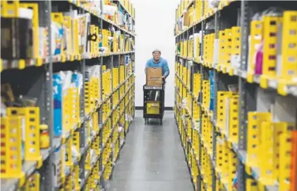  ?? Andy Cross, The Denver Post ?? Amazon associate Chris McNutt works to fulfill an order at the company’s Prime Now hub in Denver on Thursday. Prime Now customers can order online and, depending on the order, receive delivery within two hours.