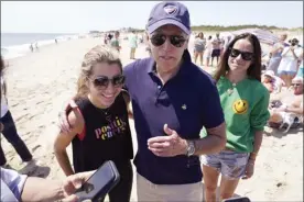  ?? ?? President Joe Biden talks to the media after walking on the beach with his granddaugh­ter Natalie Biden (left) and his daughter Ashley Biden (right) Monday at Rehoboth Beach, Del.