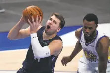  ??  ?? Dallas’ Luka Doncic gets past Andrew Wiggins on his way to a careerhigh tying 42 points.
