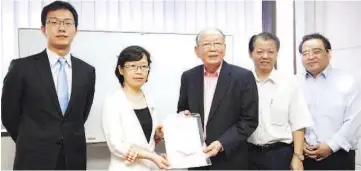  ??  ?? The Consul General of the People’s Republic of China in Kota Kinabalu, Chen Peijie (second left) presenting the invitation to The Eighth Forum on the Global Chinese Language Media to KTS Sabah area general operations manager Ngu Ngiong Hieng during the...