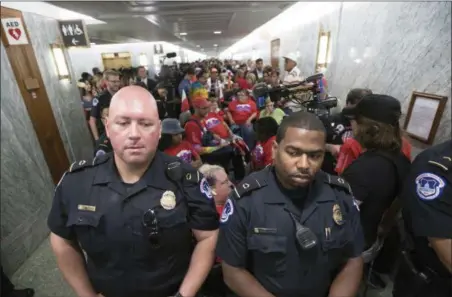  ?? J. SCOTT APPLEWHITE — THE ASSOCIATED PRESS ?? U.S. Capitol Police maintain order as hundreds of people, many with disabiliti­es, arrive for a Senate Finance Committee hearing on the last-ditch GOP push to overhaul the nation’s health care system, on Capitol Hill in Washington, Monday.