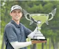  ?? AFP ?? John Catlin holds the winner’s trophy.