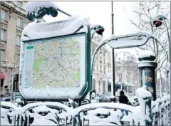  ?? STEPHANE DE SAKUTIN/AFP ?? Snow covering the entrance of a subway station is pictured yesterday following heavy snowfall in Paris.