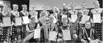  ??  ?? (Front row, from right) Ibau, Robin, Alex and Matius with their BSM awards during the London show. With them are Elizabeth, Mujan (standing – fifth and sixth left, respective­ly) and members of the Tinggang Madang dance troupe.