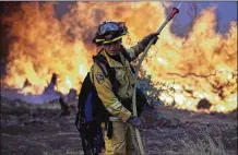  ?? MARCIO JOSE SANCHEZ / ASSOCIATED PRESS ?? A firefighte­r makes a stand in front of the advancing wildfire as it approaches a residence Saturday in Redding, Calif.