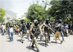  ??  ?? Policías haitianos escoltan a un grupo de personas.