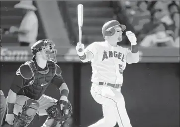  ?? Alex Gallardo Associated Press ?? KOLE CALHOUN of the Angels tracks his go-ahead home run in the seventh inning against the Seattle Mariners and catcher Mike Zunino at Angel Stadium. Calhoun had been 0 for 25 before the drive.