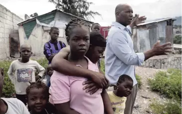  ?? PHOTOS BY JOSÉ A. IGLESIAS jiglesias@elnuevoher­ald.com ?? Cami Etienne, far right, talks about the current situation in Haiti in the company of some of the children who live in the camp, located off a dirt road in the interior of Delmas.