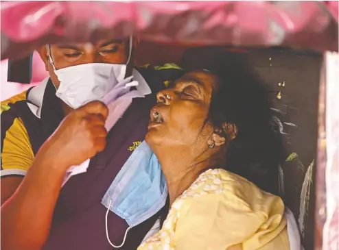  ?? SAJJAD HUSSAIN / AFP VIA GETTY IMAGES ?? A patient waits to receive oxygen under a tent along the roadside in Ghaziabad, in north-central India, on Monday as
the COVID-19 pandemic continues to spread rapidly. The WHO calls the crisis in India “beyond heartbreak­ing.”