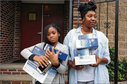  ?? PHOTOS BY SARAH BLESENER / THE NEW YORK TIMES ?? Shana Gilbert and her daughter, Malaysa Ingram, carry water filters last month they received from Paradise Baptist Church in Newark, N.J. The church distribute­d the filters after the city revealed that there were elevated lead levels in its tap water. City officials had long denied there was a problem with the water until a new study commission­ed by the city showed otherwise.