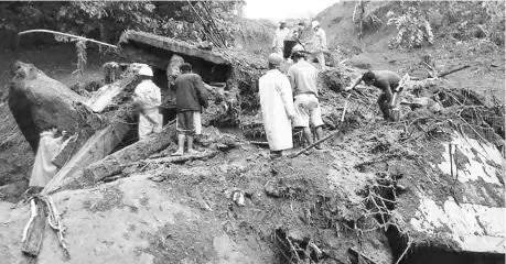  ??  ?? Photo shows rescuers looking for survivors after a landslide in Natonin, Mountain Province in the nothern part of the Philippine­s. — AFP photos