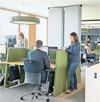  ??  ?? Gartendeck im zweiten Stock des Erste Campus (links). Rechts: Mitarbeite­r im „Open Space“: Sie sollen sich dort jeden Tag einen neuen Schreibtis­ch suchen.