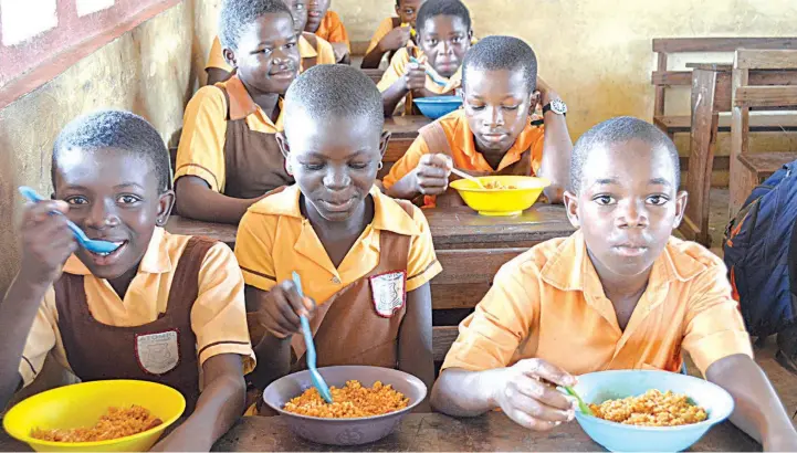  ??  ?? Pupils enjoying their free meal per day under the Federal Government’s School Feeding Programme before the COVID- 19 lockdown