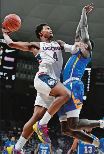  ?? JESSICA HILL/AP PHOTO ?? UConn’s Jalen Adams, left, drives to the basket as Morehead State’s Jordan Walker, right, defends during the first half of Thursday’s men’s college basketball game in Storrs. UConn used its all-out hustle, from both players and coaches, to win 80-70 in the first game of the coach Dan Hurley era.