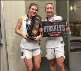  ?? MEDIANEWS GROUP PHOTO ?? Archbishop Wood seniors Kaitlyn Orihel (left) and Noelle Baxter pose with the PIAA Class 4A trophy and giant Hershey’s Bar after winning a state title in their final game as teammates.