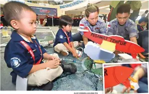  ?? ALLEX QOMARULLAH/JAWA POS ?? TEKNOLOGI SEDERHANA: Abqory (kiri) dan Khan mengikuti lomba robot hidraulik di Lenmarc Mall. Foto kanan, suntikan dengan slang air yang dipakai untuk menggerakk­an robot berbahan gabus.