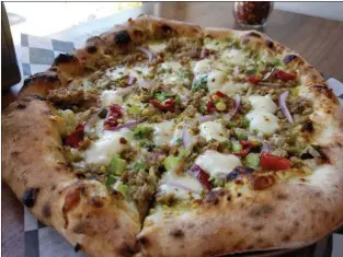 ?? MARK KOESTNER — FOR THE NEWS-HERALD ?? Citizen Pie’s Americano is topped with fresh mozzarella, Italian sausage and red and green onions.
